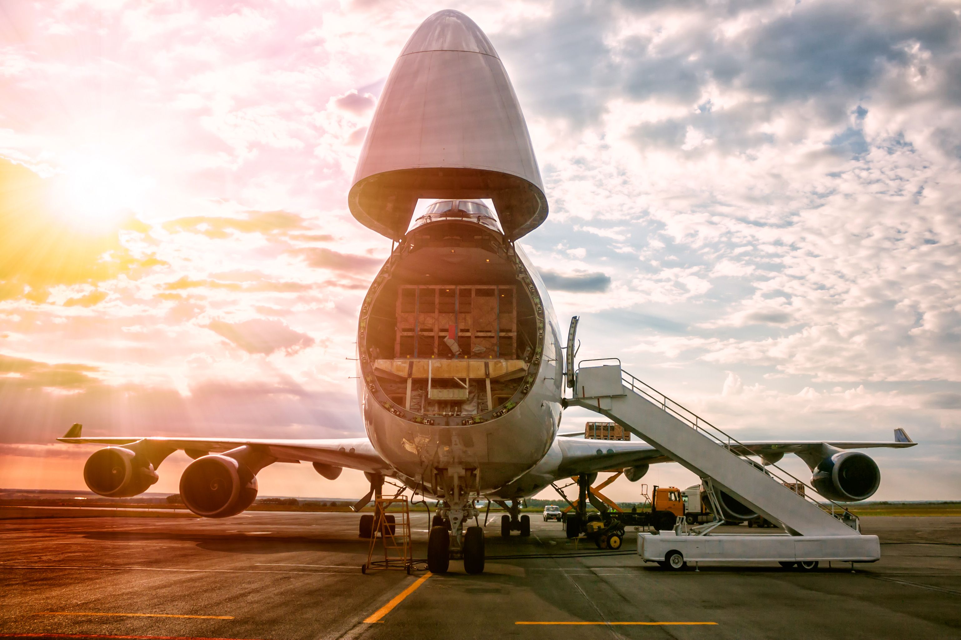 A large cargo aircraft being loaded on an airport apron.