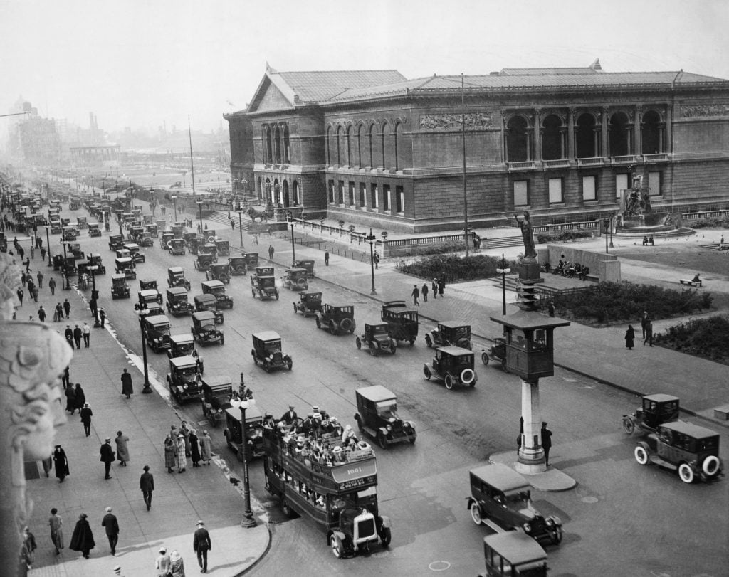 A large neoclassical-style building on a broad boulevard. 