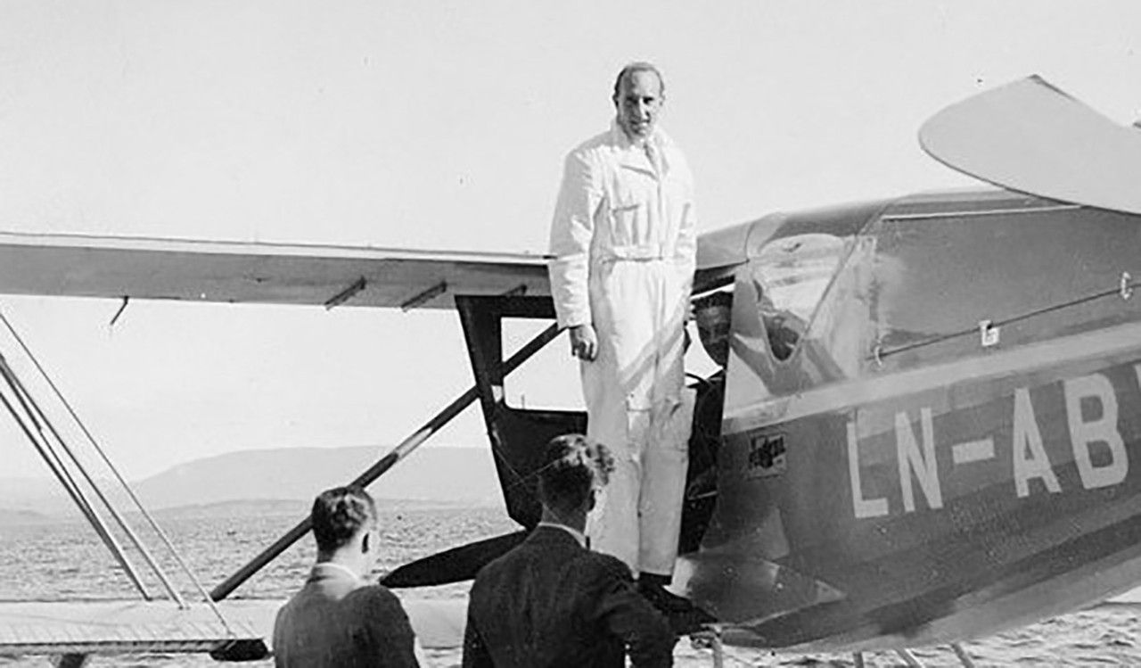 Viggo Wideroe standing near a biplane.