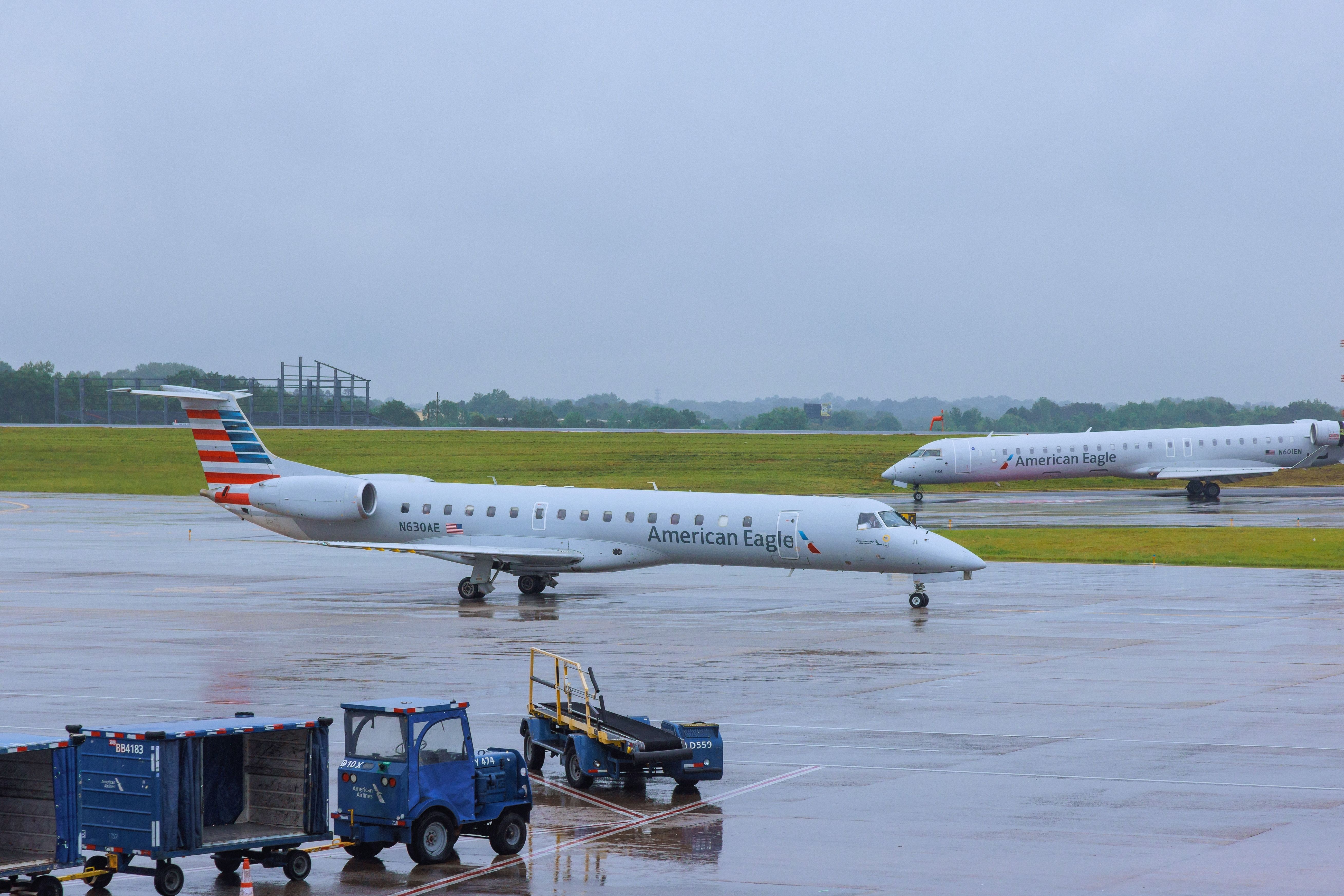 Two American Airlines Embraer E145s at rainy CLT shutterstock_2330229835