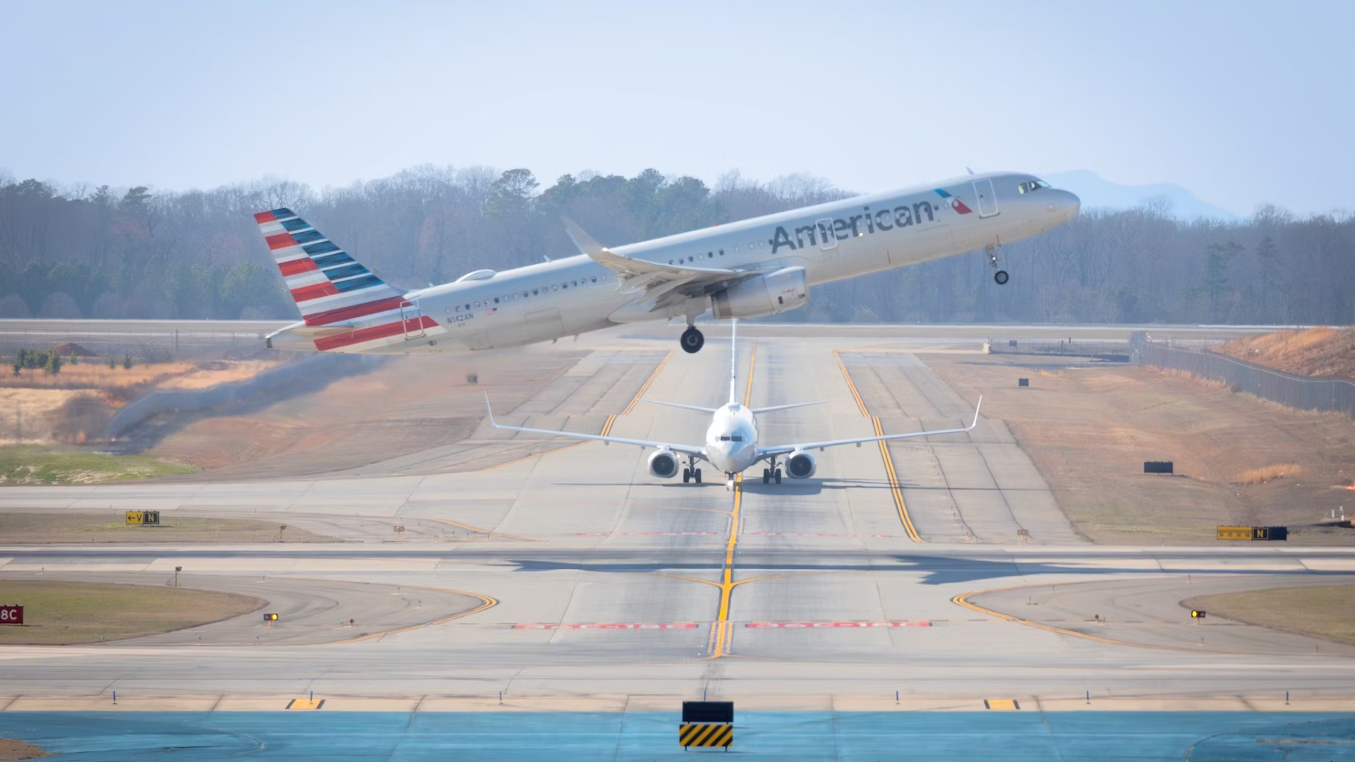 American Airlines Airbus A321 taking off with Boeing 737-823 in the background at Charlotte Douglas International Airport FI