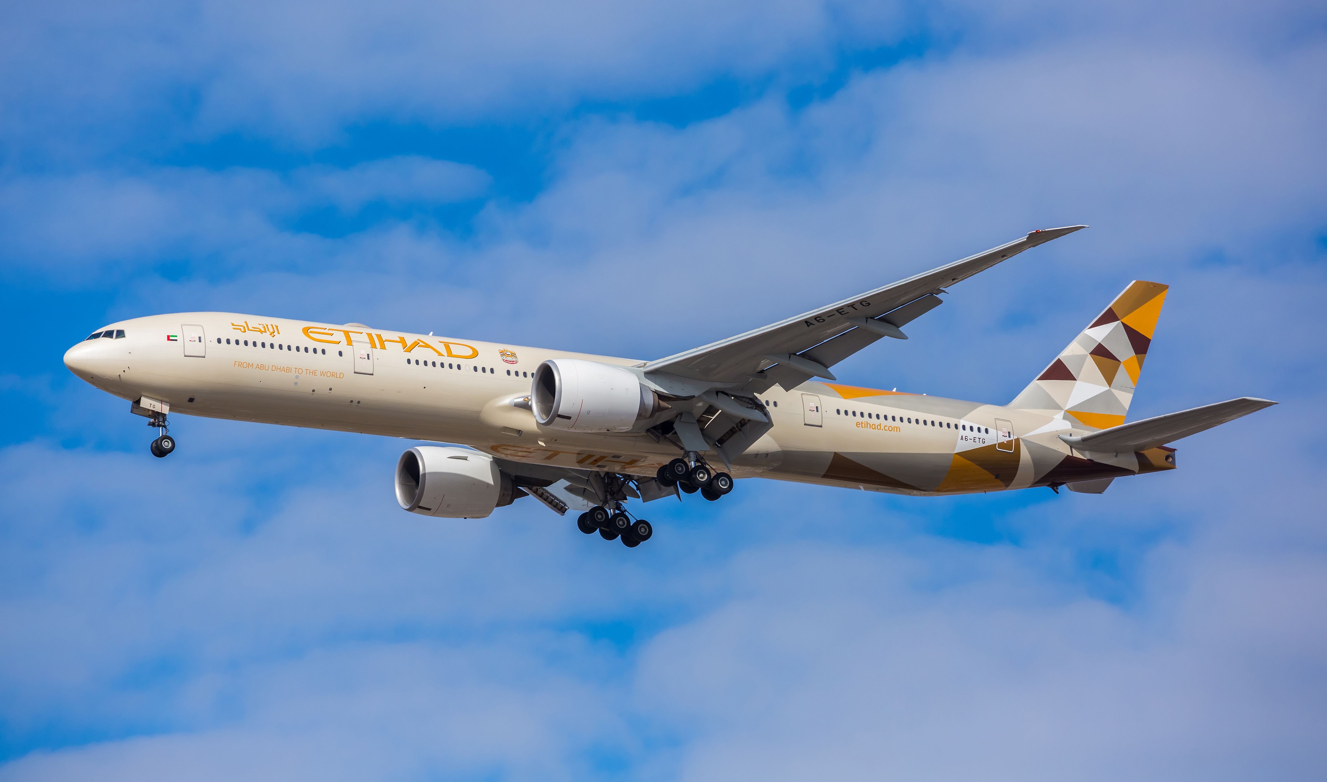 An Etihad Airways Boeing 777-300ER flying in the sky.