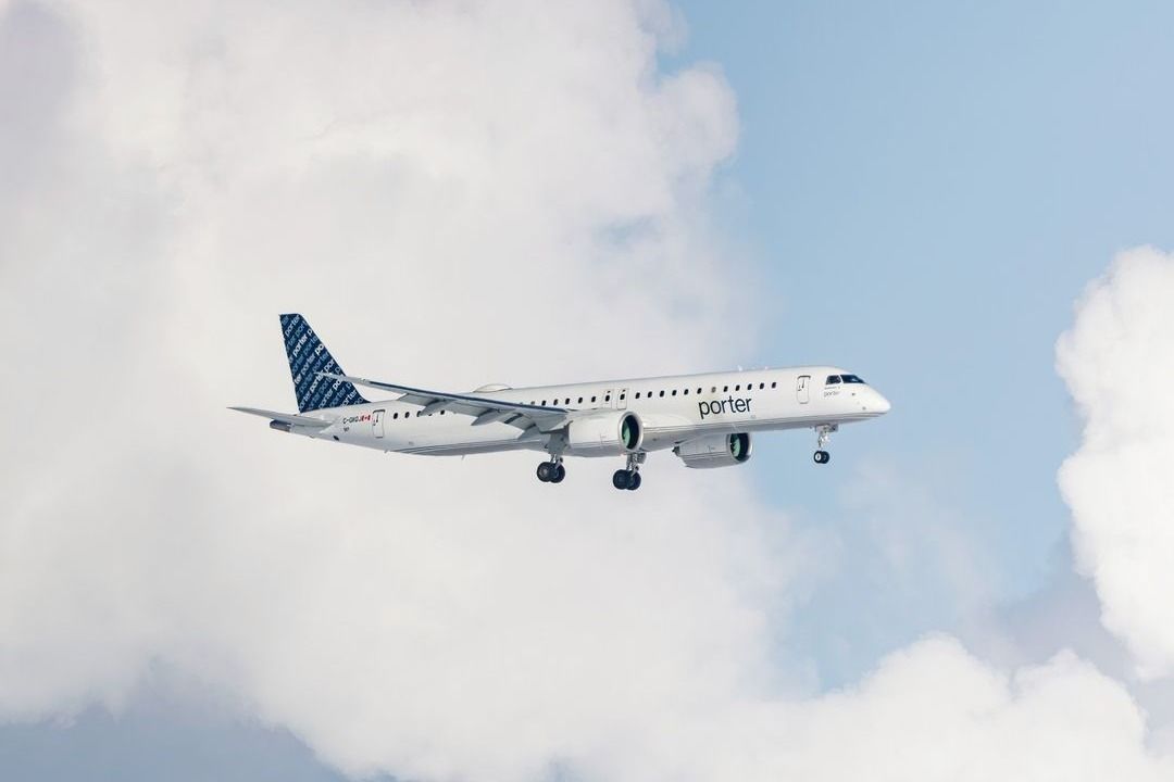 A Porter Airlines Embraer E195-E2 with clouds in the background. 