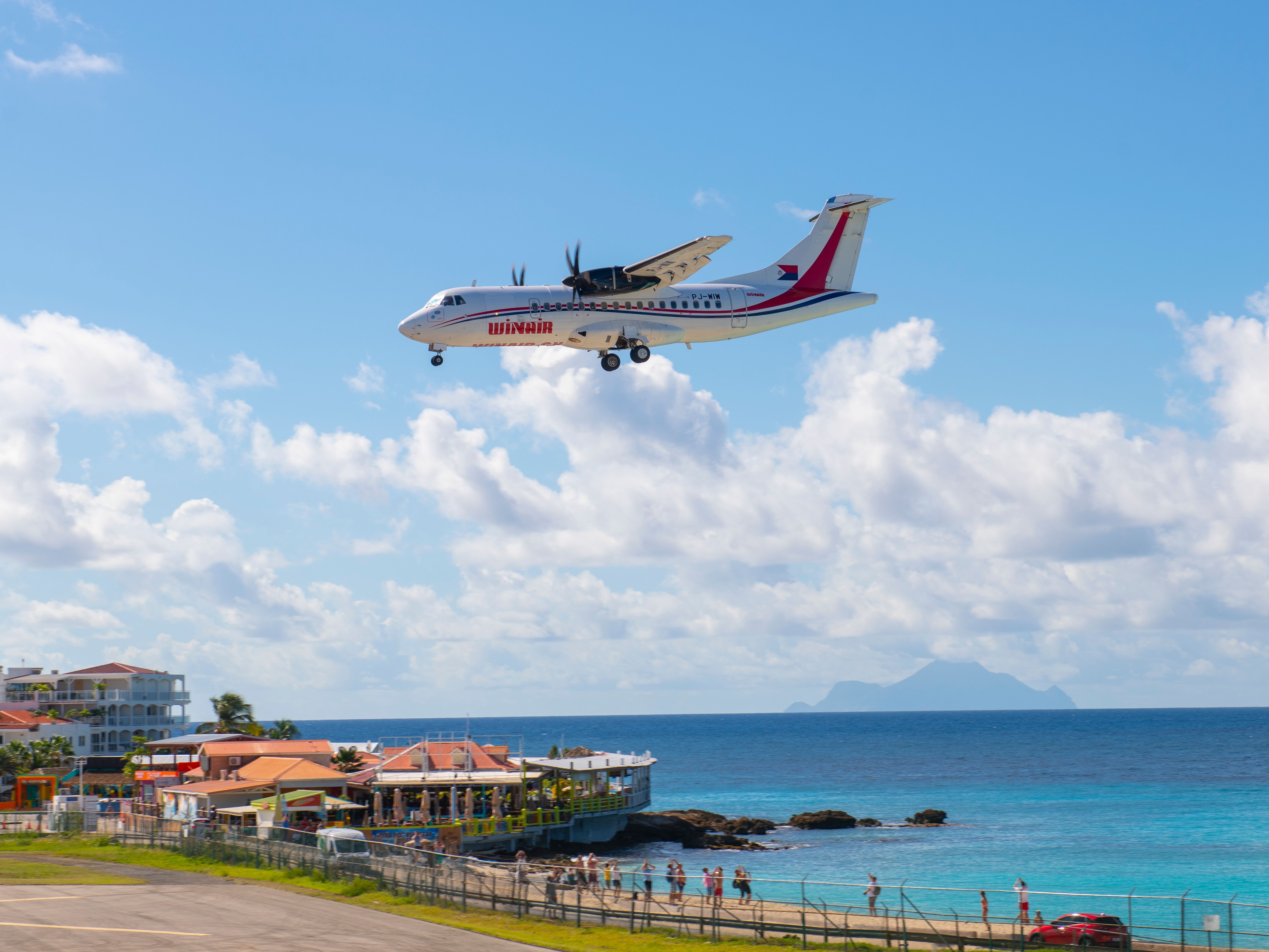Winair (Windward Islands Airways) ATR 42 flying over Maho Beach before landing on Princess Juliana International Airport SXM on Sint Maarten, Dutch Caribbean.