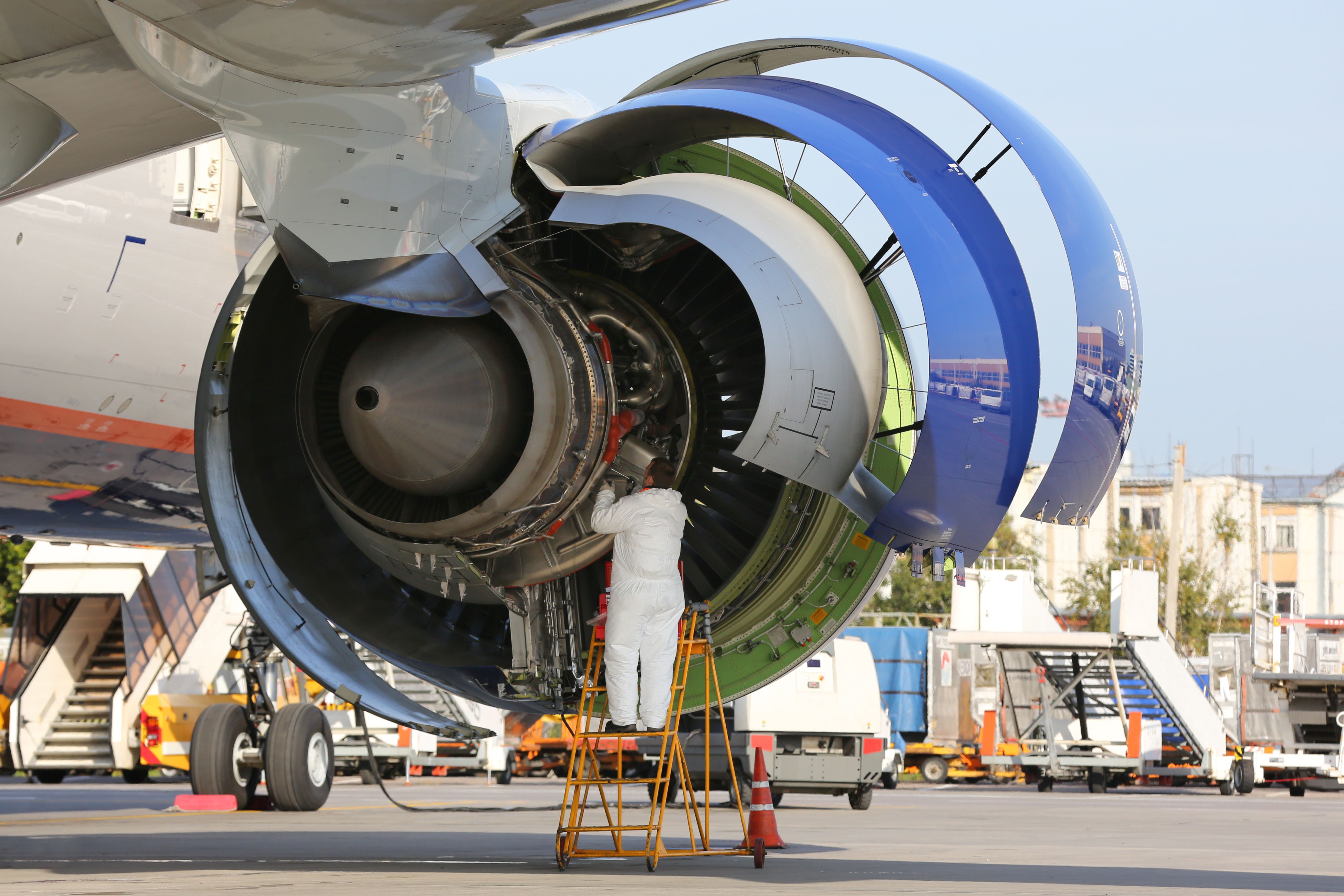 An engine being maintainted by an engineer. 