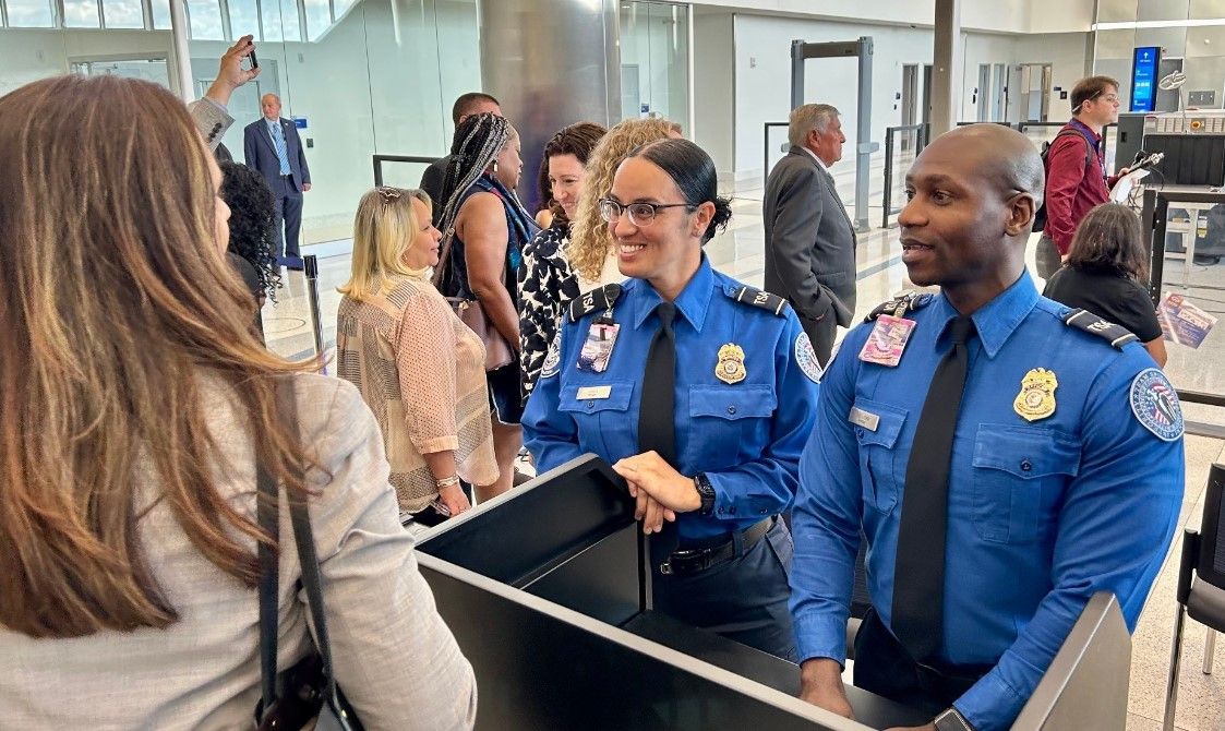 TSA officers greeting passengers.