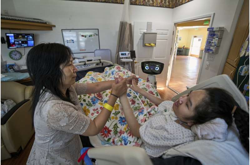 Cara Nguyen with her daughter, Kathy, 18, are visited by Robin the Robot at the HealthBridge Orange Specialty Pediatric Hospital in Orange, Calif., on Friday, Sept. 12, 2025.Credit: AP Photo/Damian Dovarganes A robot programmed to act like a 7-year-old girl works to combat fear and loneliness in hospitals