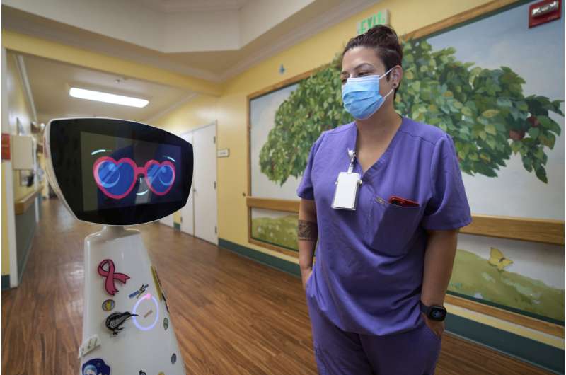 Activities Coordinator Melissa Delaney interacts with Robin the Robot as it visits patients' rooms at the HealthBridge Orange Specialty Pediatric Hospital in Orange, Calif., on Friday, Sept. 12, 2025. Credit: AP Photo/Damian Dovarganes A robot programmed to act like a 7-year-old girl works to combat fear and loneliness in hospitals