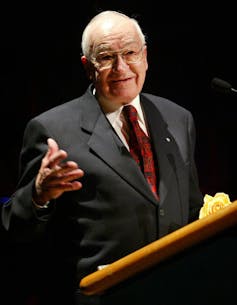 A man at a podium in suit.
