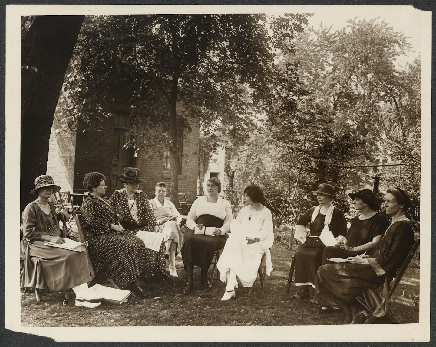 National Council Meeting, 1924.
Description	
Summary: Photograph of National Woman's Party council members sitting in a half-circle under a tree. L-R: Dora Ogle, Mrs. J.D. Wilkinson, Dora Lewis, Lavinia Egan, Edith Ainge, Alice Paul, Martha Souder, Florence Boeckel, Edith Hooker (Nev.)

L-R: 1. Dora Ogle (Md), 2. Mrs. J.D. Wilkinson (La), 3. Mrs. Lawrence Lewis (Pa), 4. Lavinia Egan (La), 5. Edith Ainge (N.Y.), 6. Alice Paul (N.J.), 7. Martha Souder (Pa), 8. Florence Boeckel (D.C.), 9. Edith Hooker (Nev.)