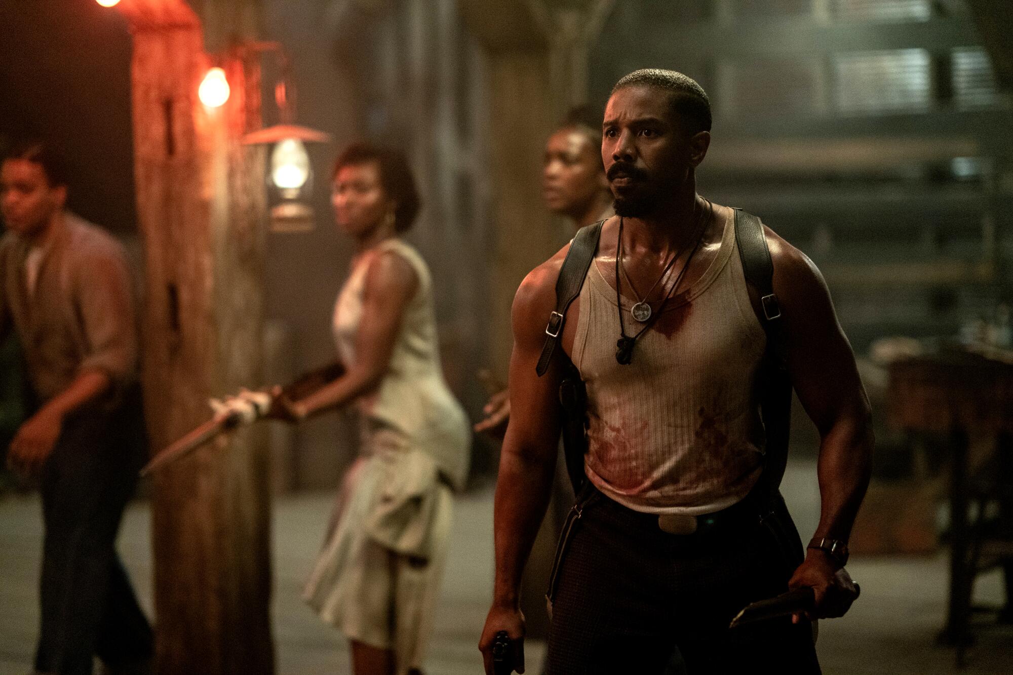 Michael B. Jordan, wearing a blood-soaked white tank undershirt, in "Sinners." 