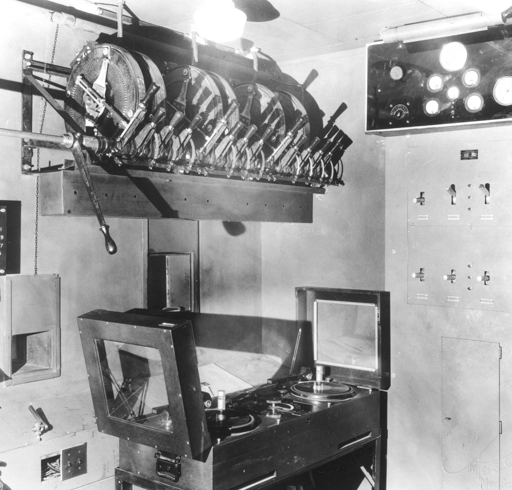 The Holly Theatre’s projection booth, photographed in the early 1930s, housed the equipment needed to run the new synchronized sound films that defined the era of “talking pictures.” The theater was the first in Medford built specifically to accommodate the technology required for sound motion pictures. Photo courtesy: Southern Oregon Historical Society