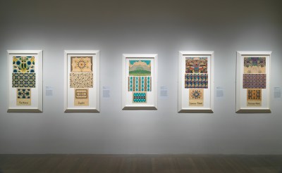 5 veritcal patterned tryptichs hang on a gallery wall.