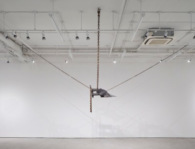 An iron-like form suspended from the ceiling by chains.