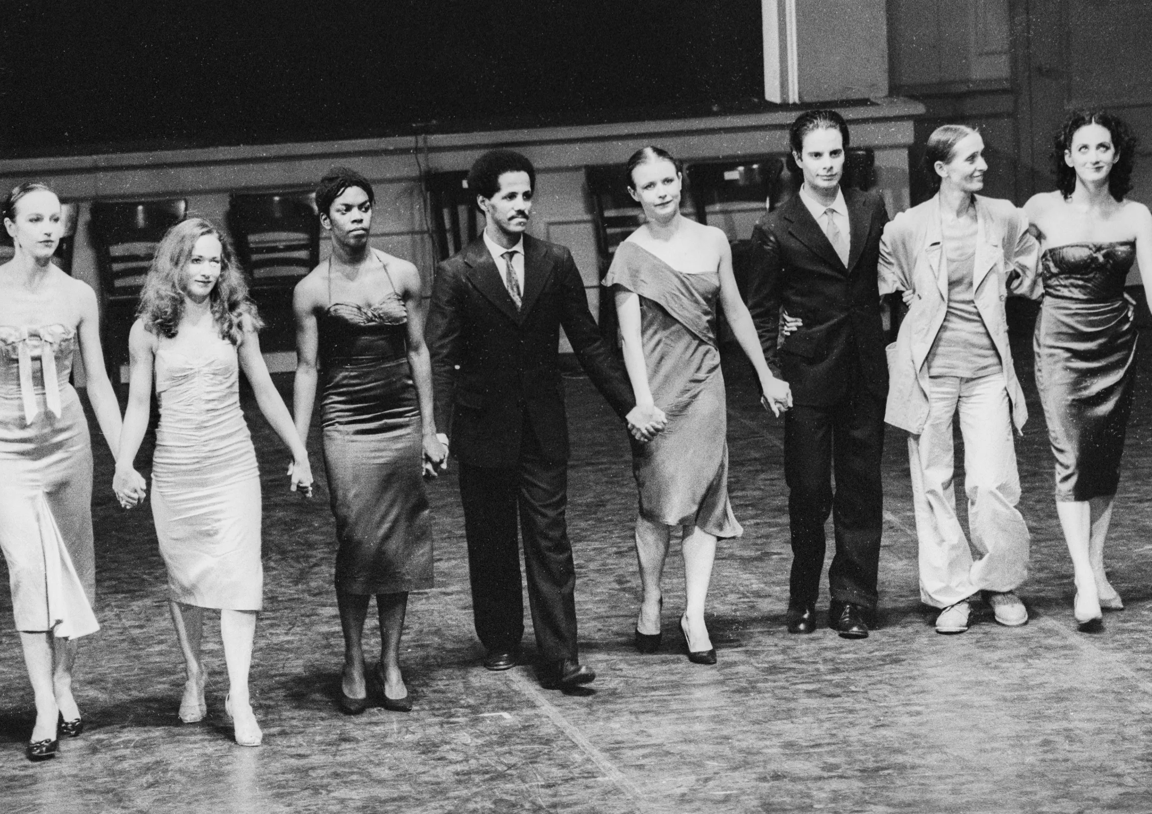 A group of nine dancers, four men and five women, holding hands and bowing on stage at the 1978 Kontakthof premiere.
