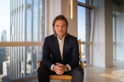 A man in a suit sitting on a chair.