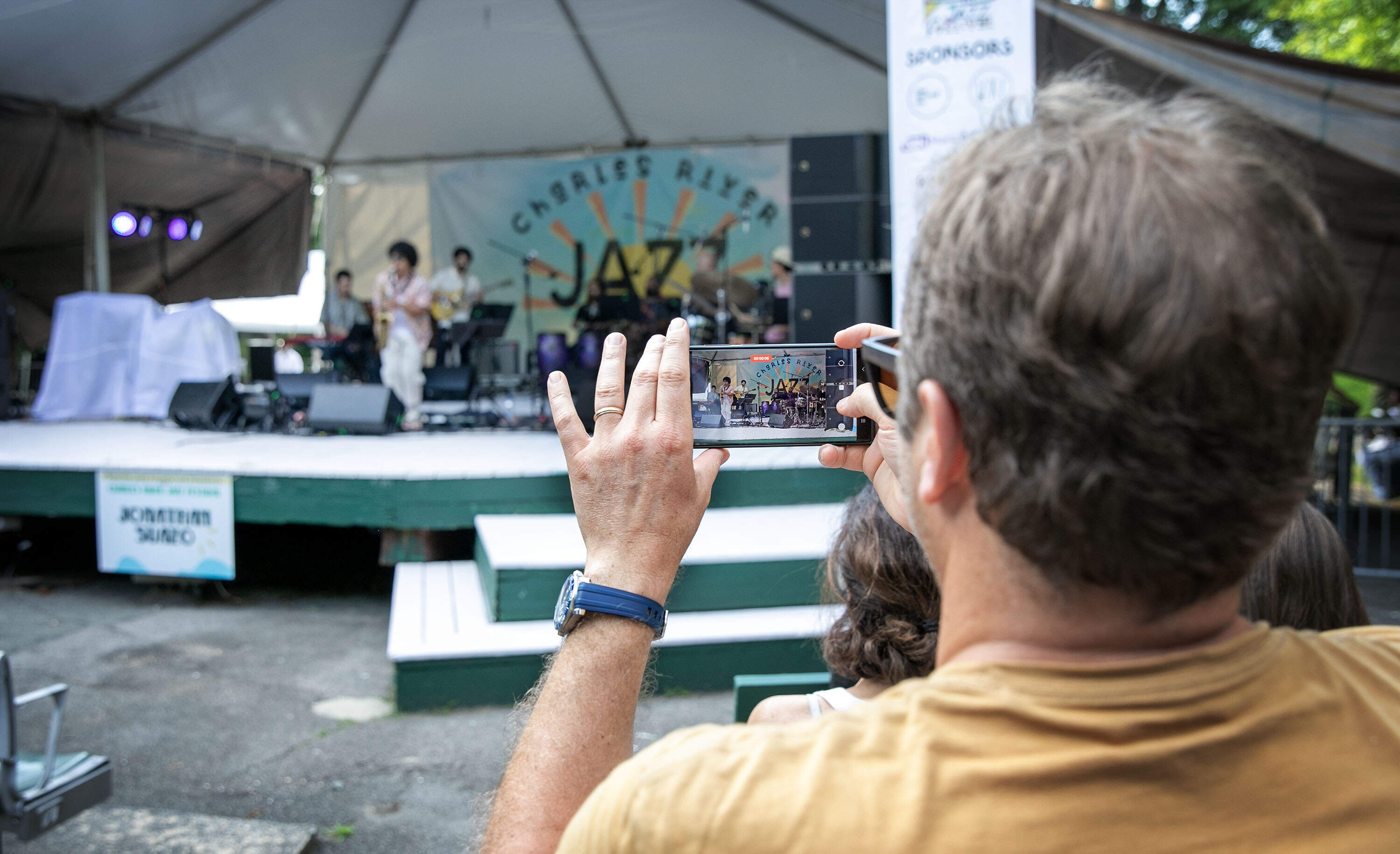 An audience member records a band at the Charles River Jazz Festival, at Herter Park Amphitheater in Boston. (Robin Lubbock/WBUR)