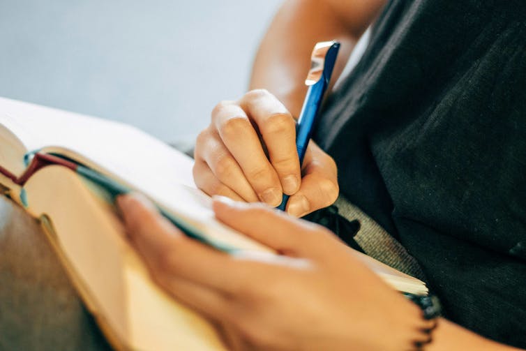 A person taking notes in a book