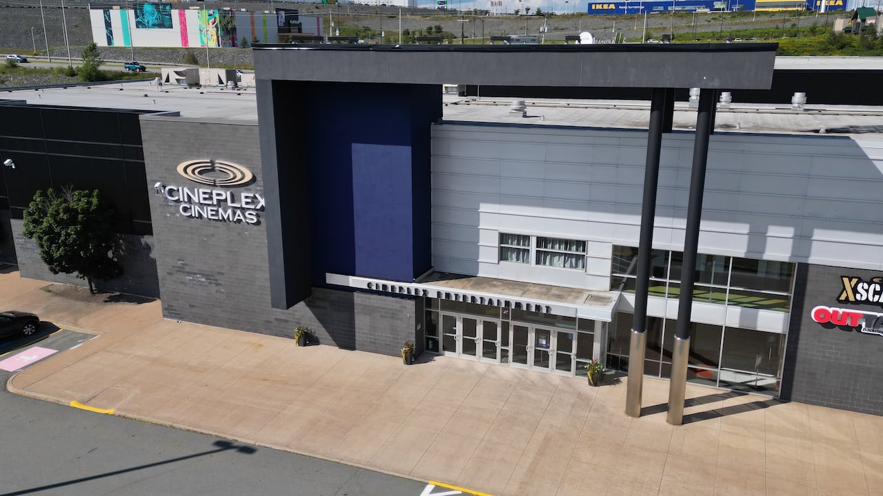 A big grey box store viewed from above that says Cineplex Cinemas on one of its outer walls.