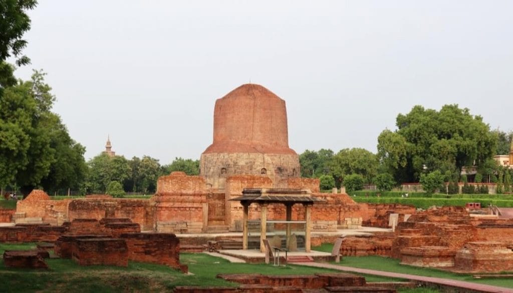 a ground view of a reddish stone site that holds the remains of Sarnath