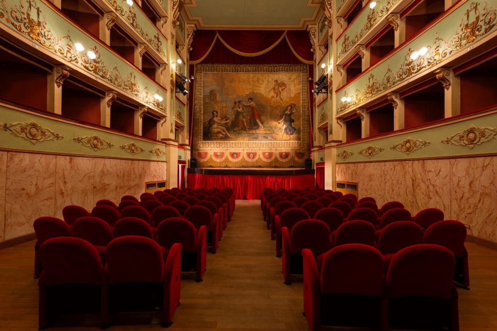 a red seated old-fashioned box theatre in Italy that was chosen as part of a group of 10 by UNESCO