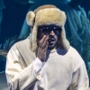 Singer and rapper Bad Bunny standing on stage with supporting musicians.