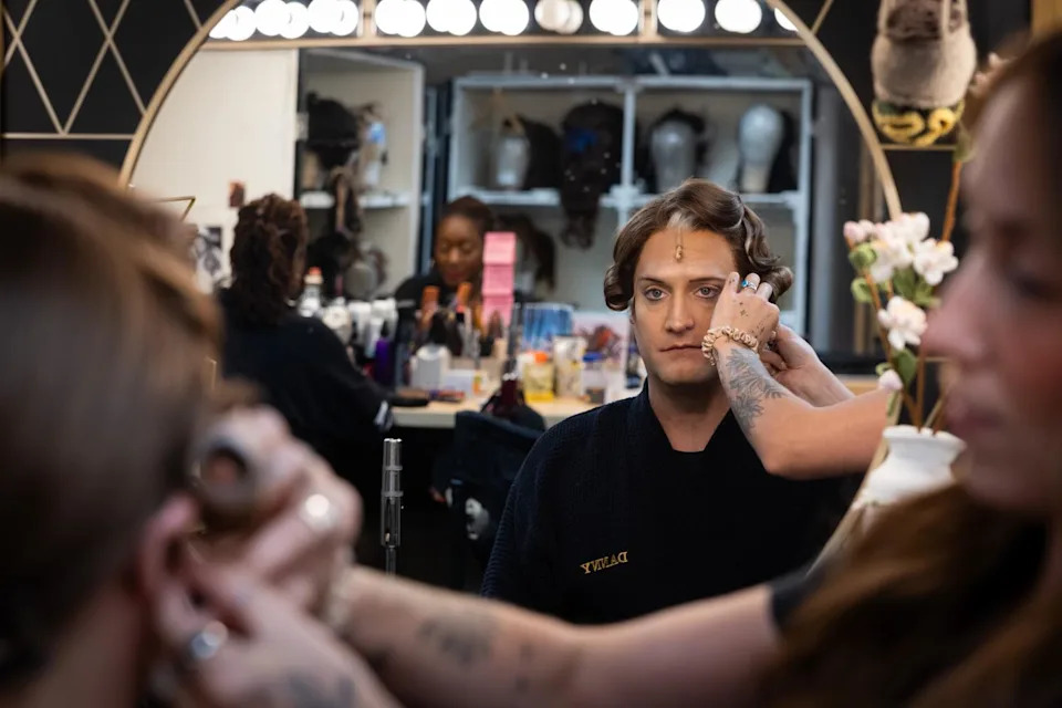 An actor gets fitted with a wig.