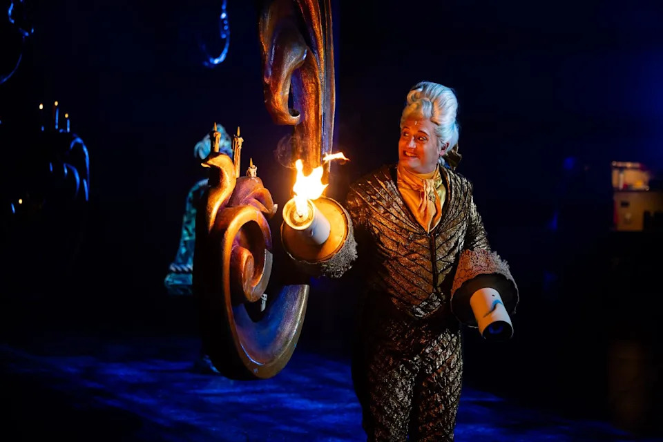 An actor with a flame prop on his hand.