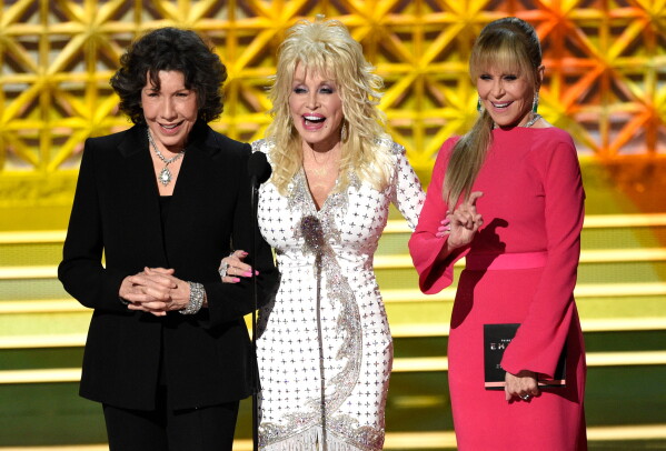 Dolly Parton, center, stands on stage with Lily Tomlin, left, and Jane Fonda at the 69th Primetime Emmy Awards in Los Angeles, Sept. 17, 2017. (Photo by Chris Pizzello/Invision/AP)