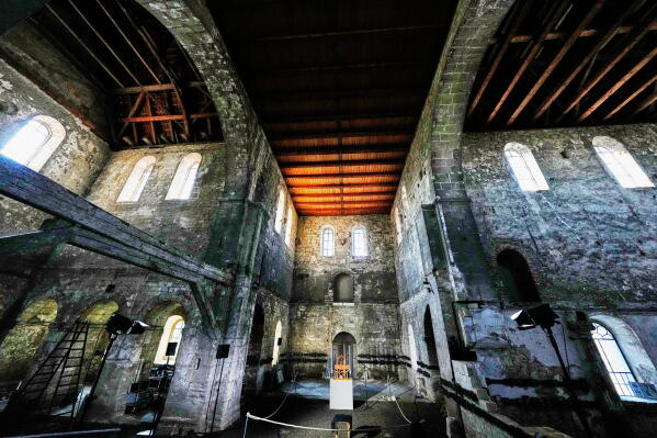 The organ, center, of the John Cage Organ Project Halberstadt is illuminated prior to a chord change of the organ inside the medieval Burchardi Church in Halberstadt, Germany, Wednesday, Aug. 5, 2026. (AP Photo/Markus Schreiber)