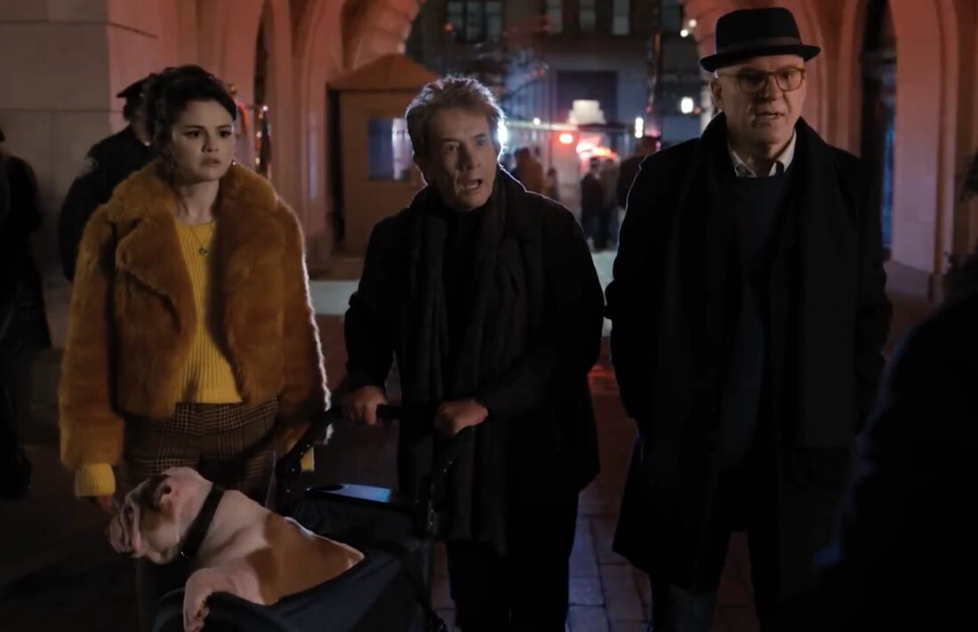 Mabel, Oliver (with Winnie in stroller), and Charles in front of the Arconia, shocked to hear of a death in Only Murders in the Building