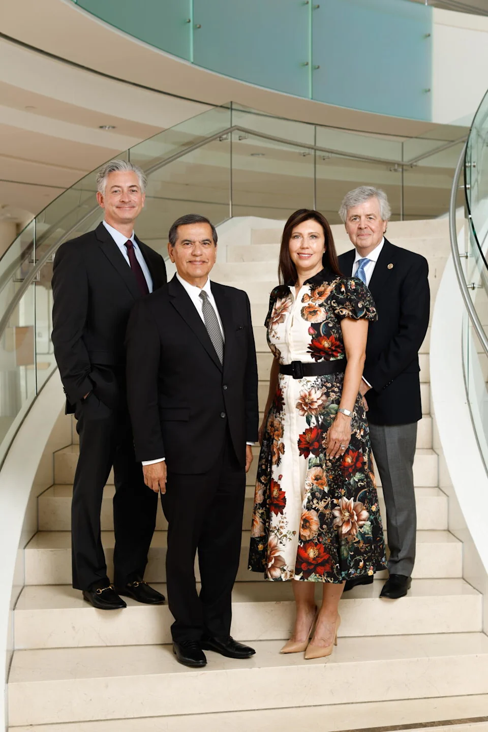 A group of arts leaders pose for a portrait on some steps.