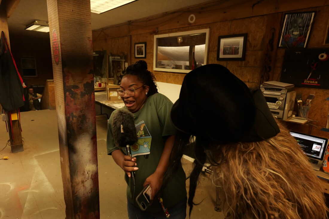 Scare-actor Jermaine Hoes (right) in costume scares host Ayesha Rascoe mid-interview.