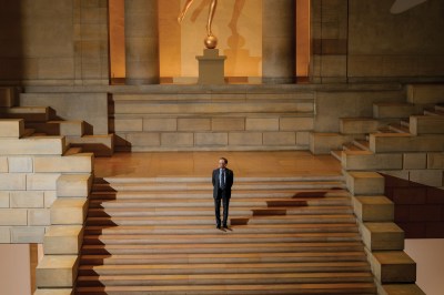 A man standing on a grand staircase.