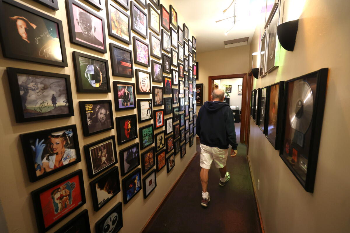 Conway Recording Studios founder Buddy Brundo, 83, walks down a hallway of framed album covers.