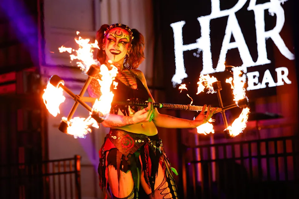 Fire spinning flow artists perform at a Halloween show.