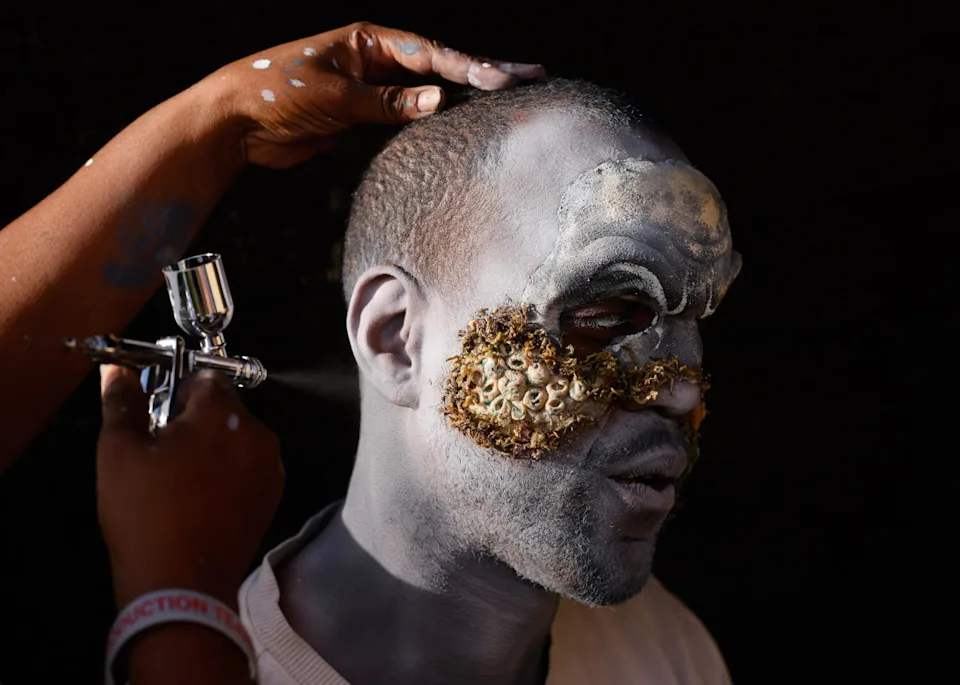 A scare actor with barnacle makeup on his face.